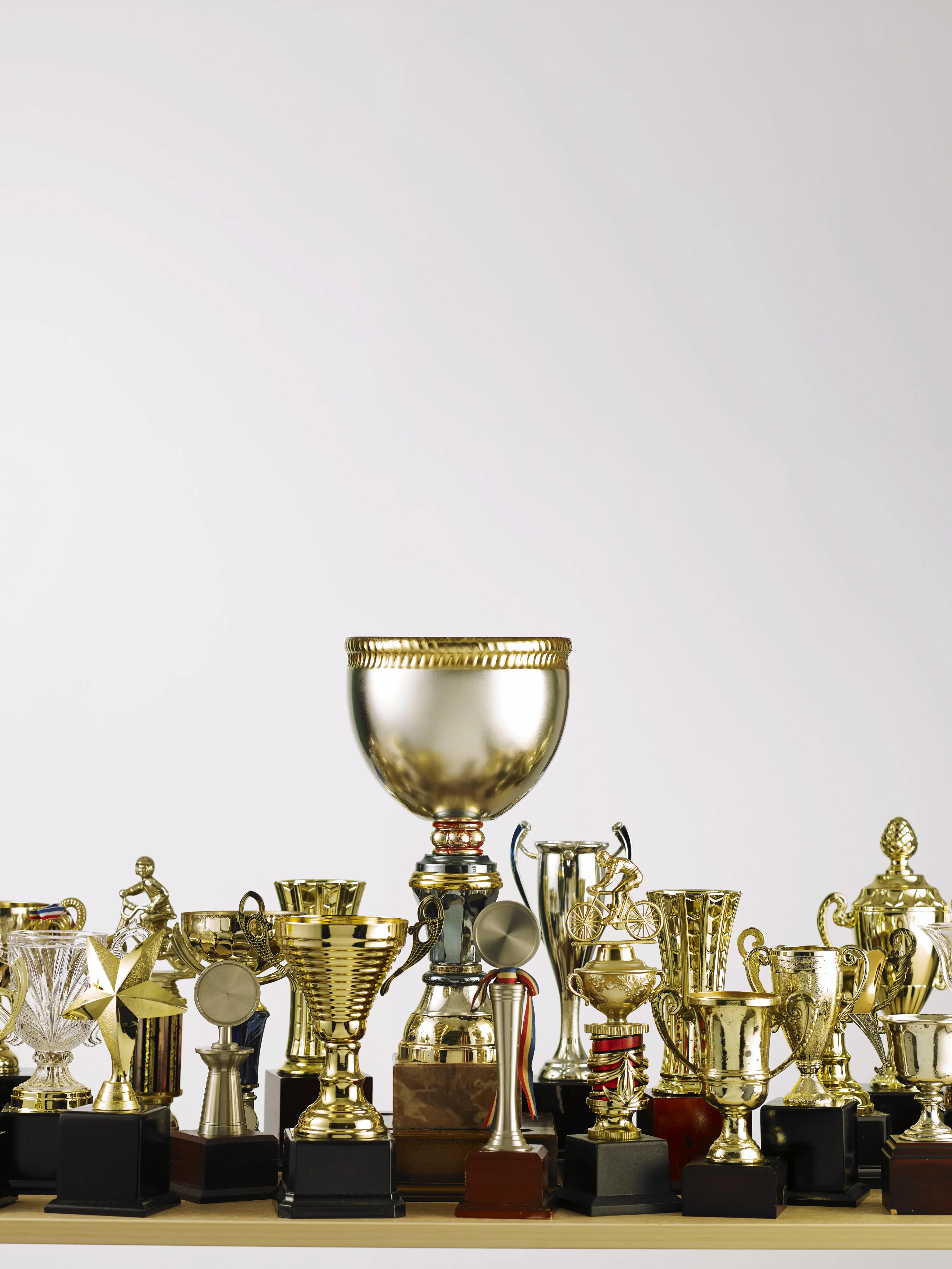 Nahaufnahme von Trophäen auf einem Tisch vor weißem Hintergrund.