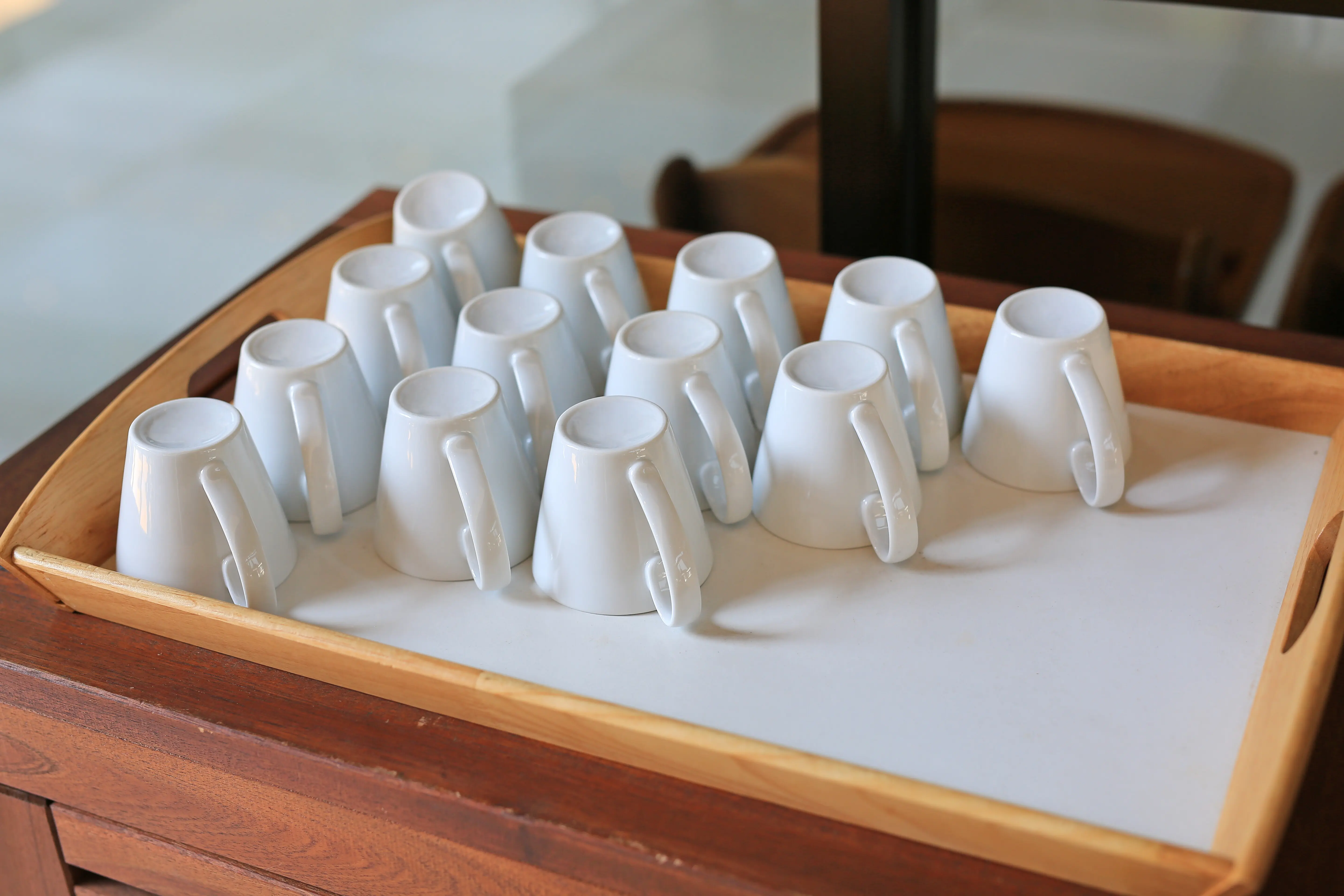 Umgedrehte Kaffeetasse auf einem Holztablett.