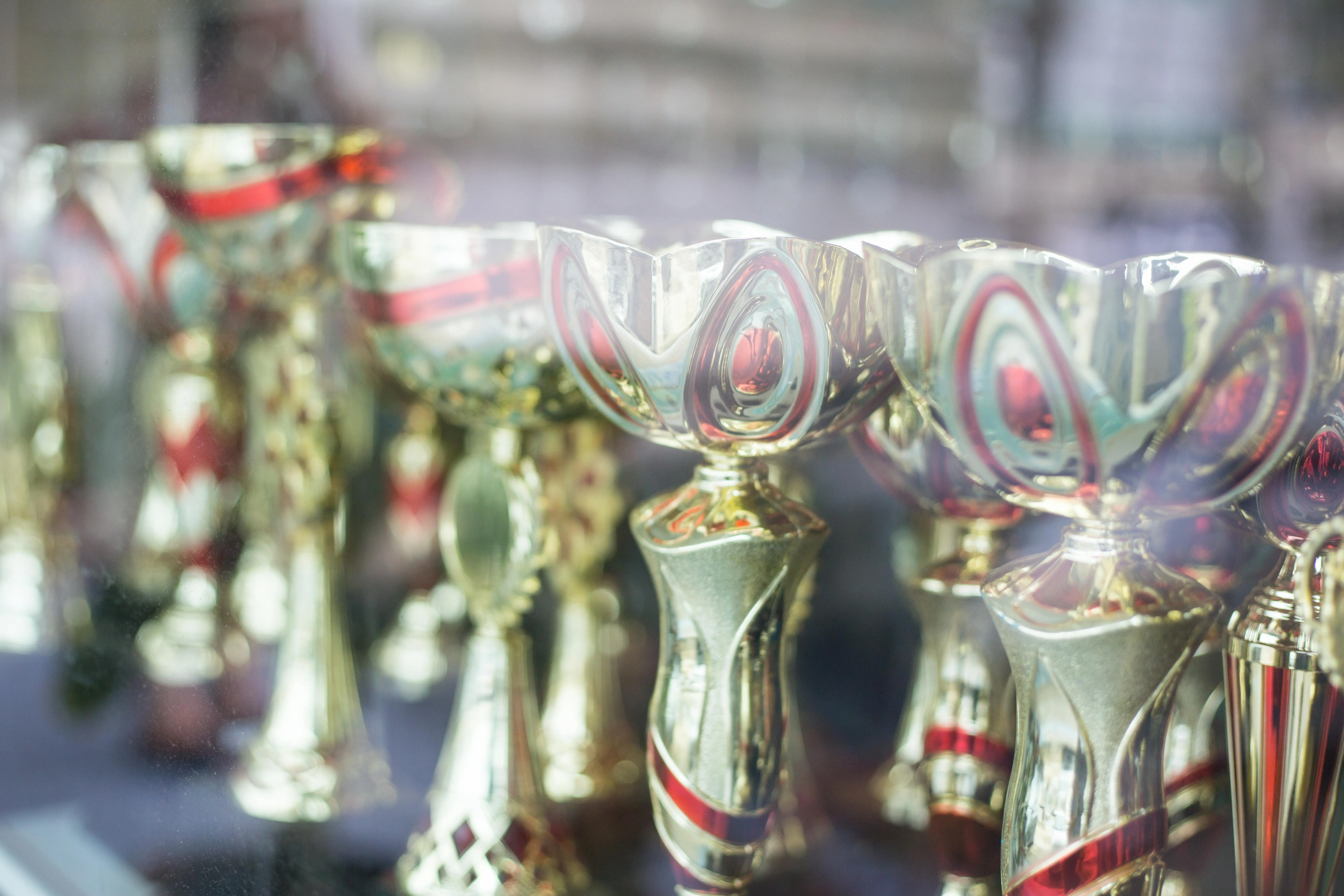 Nahaufnahme einer Gruppe glänzender goldener Trophäen, die auf ihre Gewinner warten.